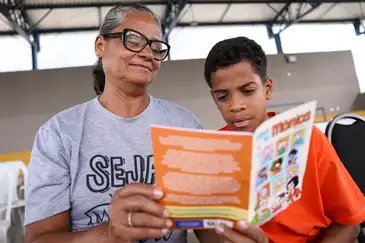 Brasília (DF), 26/03/2025 - Varlinda Leite e seu neto, Arthur Diogo, participam do lançamento de gibi da Turma da Mônica sobre intergeracionalidade em escola no Itapoã, região administrativa do Distrito Federal. Foto: Marcelo Camargo/Agência Brasil