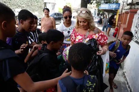 Rio de Janeiro (RJ), 27/09/2025 – A aposentada Tânia Ponciano distribui doces e brinquedos para crianças no Dia de Cosme e Damião, santos católicos também adorados nas religiões de matriz africana, nas ruas do bairro do Andaraí, Zona Norte da cidade. Foto: Fernando Frazão/Agência Brasil