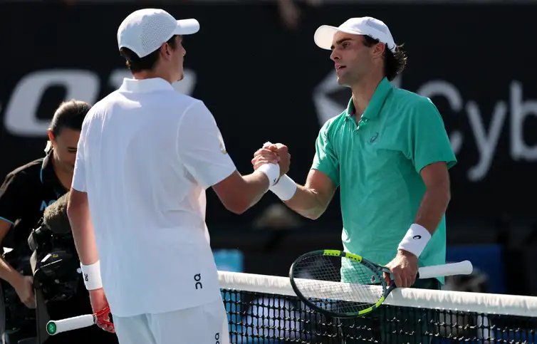 Tennis - Australian Open - Melbourne Park, Melbourne, Australia - January 20, 2026 Eliot Spizzirri of the U.S. shakes hands with Brazil's Joao Fonseca after winning his first round match REUTERS/Edgar Su