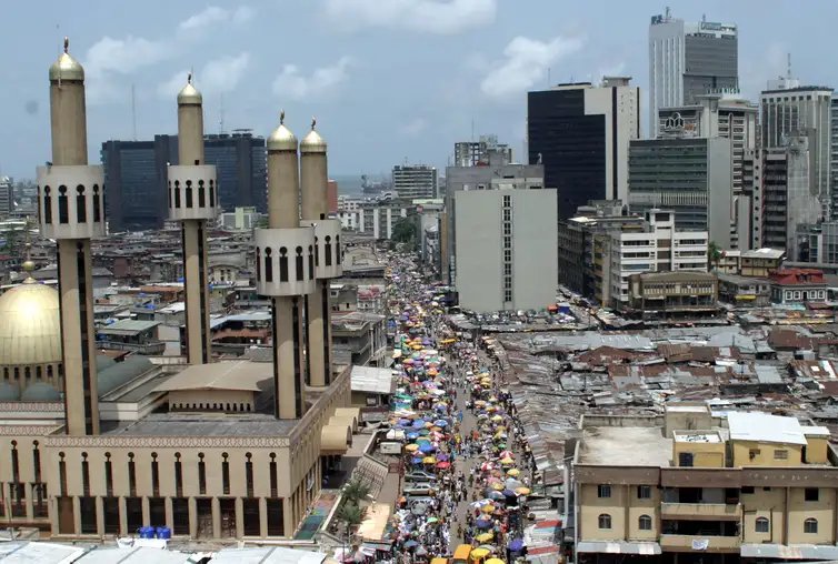 Reuters/George Esiri/Arquivo/Proibida reprodução People and traffic move along a busy street in Lagos, Nigeria, May 24,2005. The African Union (AU) celebrates Africa Day on Wednesday May 25, marking the anniversary of the founding in 1963 of the Organization of African Unity, replaced in 2002 by the AU as the driving force behind the struggle for peace, democracy, development, human rights and good governance on the worlds poorest continent. REUTERS/George Esiri FOR/LA